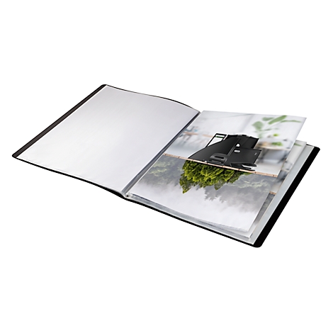 Offenes, schwarzes Fotoalbum mit Bildern von Natur und Gebäuden.