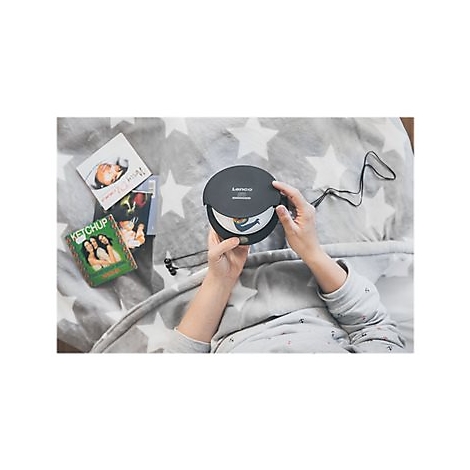 Person hÃ¤lt einen schwarzen CD-Player mit geÃ¶ffnetem Deckel. Auf einem grauen Sternenmuster-Bett liegen CDs daneben.