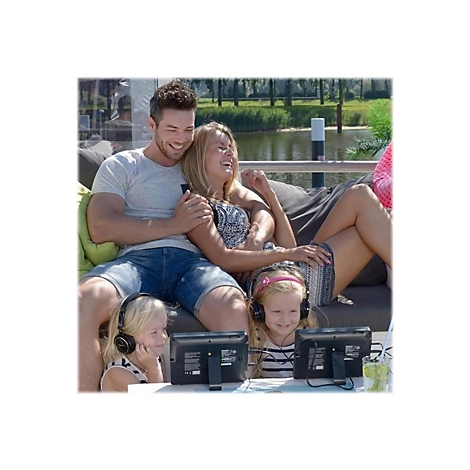 Eine Familie sitzt auf einer Couch im Freien. Sie schauen alle auf kleine Bildschirme und tragen KopfhÃ¶rer, wÃ¤hrend sie lachen.