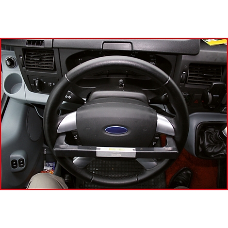 Nahaufnahme des Lenkrads eines Ford-Transporters, mit dem blauen Ford-Logo. Das Lenkrad hat ein zusätzliches Bedienelement.