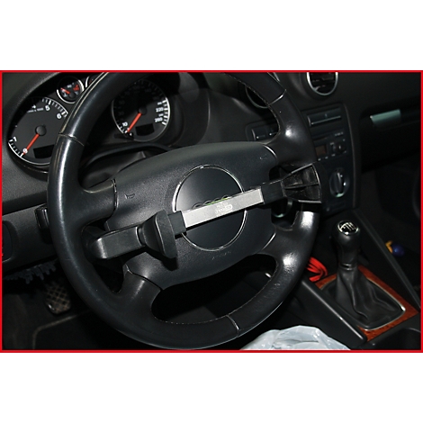 Lenkrad eines Autos mit montierter Diebstahlsicherung. Das Schloss ist silberfarben und befindet sich mittig.