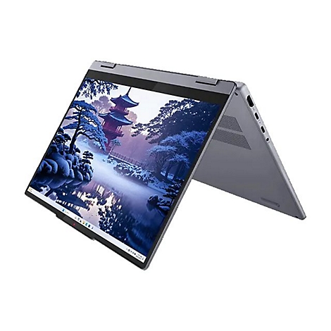 Ein Laptop mit einem Display, das eine Winterlandschaft zeigt, steht geöffnet auf einer weißen Oberfläche.