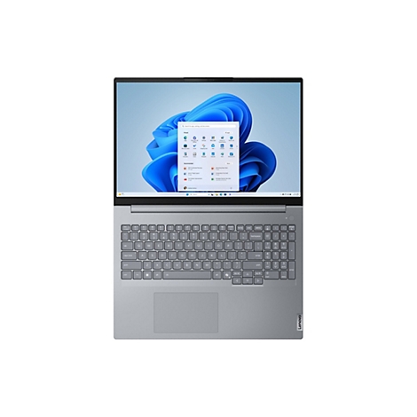 Ein silberner Laptop mit geöffnetem Bildschirm zeigt das Windows 11-Betriebssystem. Die Tastatur und das Trackpad sind sichtbar. Der Laptop ist auf einer weißen Oberfläche platziert.