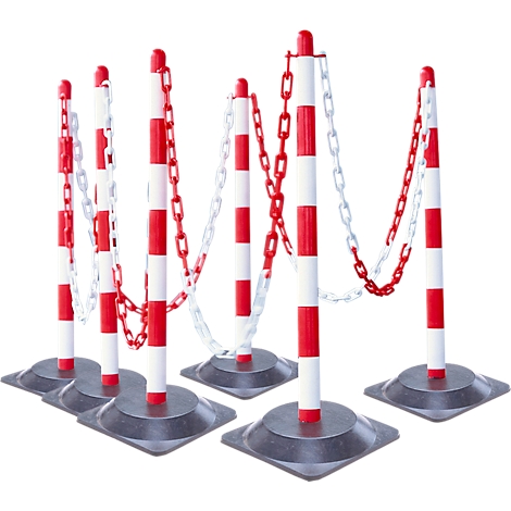 Red and white striped barrier posts with chains, on a grey surface.