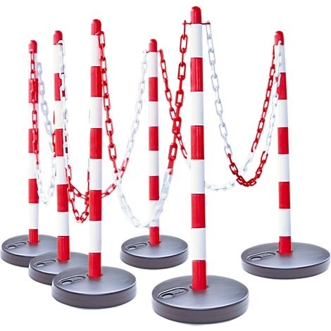 Row of red and white striped barrier posts with chains, on gray ground.