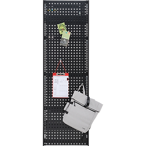 Schwarze Lochwand mit Zetteln, Notizblock und helle Tasche. Die Lochwand hat quadratische Löcher. Zettel und Notizblock werden mit Klammern und Haken befestigt.