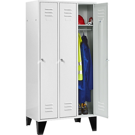 White cabinet with three doors. One door open, work clothes visible. Red helmet and safety shoes on top.