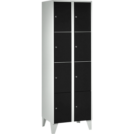 White cabinet with eight black doors. The cabinet stands on feet.