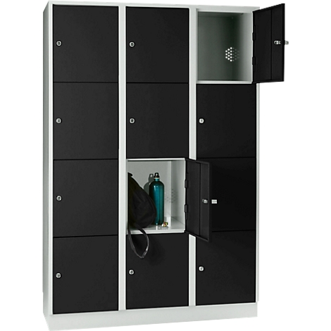 A locker with black doors and white frames, two doors are open. A bag and a bottle can be seen in one.