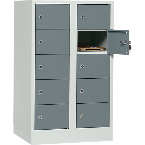 Gray cabinet with multiple compartments, one compartment open, keys in lock.
