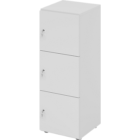 Driedelig, witte kast met sleutelsloten. Elke lade heeft een eigen slot.