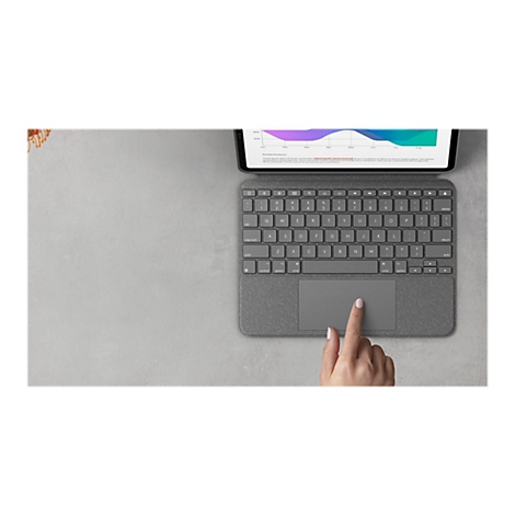 Draufsicht auf ein graues Tablet mit Tastatur. Eine Hand tippt auf das Touchpad. Im Hintergrund ist eine Analyse zu sehen.