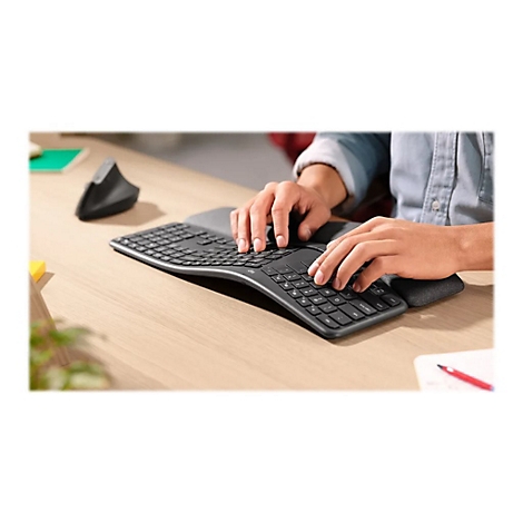 Personne tapant des deux mains sur un clavier ergonomique.
