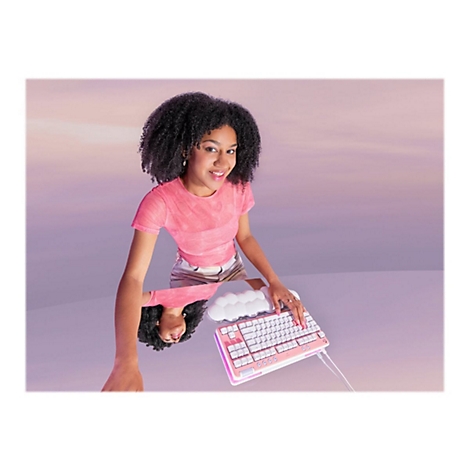Eine lächelnde Frau mit Locken, rosa Oberteil, an einem Keyboard, das auf einer Oberfläche gespiegelt wird.