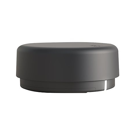 Un appareil noir et rond avec une ligne blanche. L'appareil est placé sur un fond blanc.