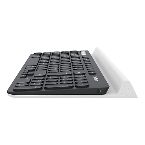 Draufsicht auf eine schwarze Tastatur, die auf einer weißen Ablage liegt.