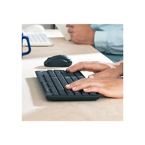 Nahaufnahme einer Person, die eine schwarze Tastatur bedient. Die Hände der Person sind über der Tastatur platziert.