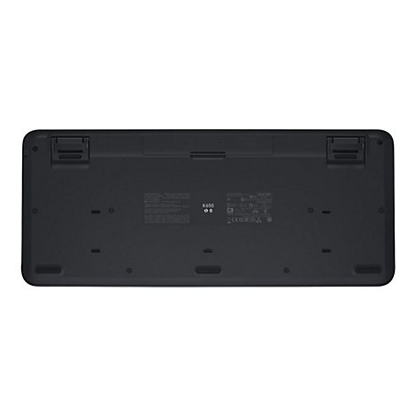 Die Unterseite einer schwarzen Logitech K650 Tastatur. Es gibt viele Kennzeichnungen und Stützfüße.