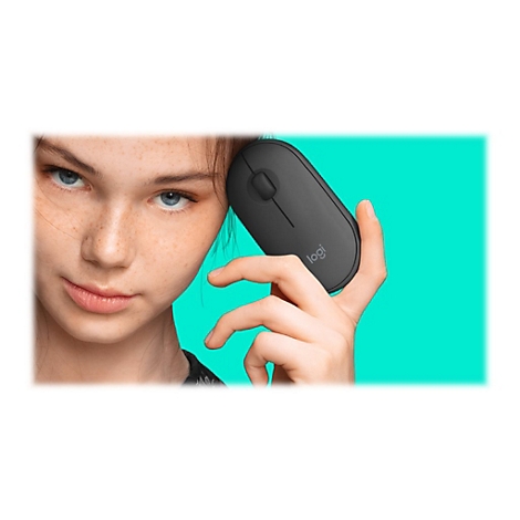Junge Frau mit Sommersprossen hält eine schwarze Maus. Der Maus steht das Logo 'logi'. Hintergrund türkis.