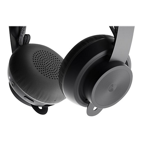 Casque audio sombre, gros plan sur les oreillettes. Une oreillette a une grille, l'autre montre une partie mÃ©tallique lisse.