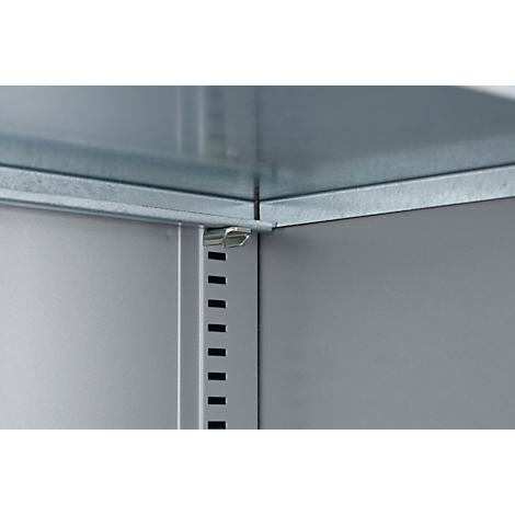 Detailansicht einer Eckverbindung eines Metallregals. Graue Metallplatten, verzahnt mit kleinen Halterungen.