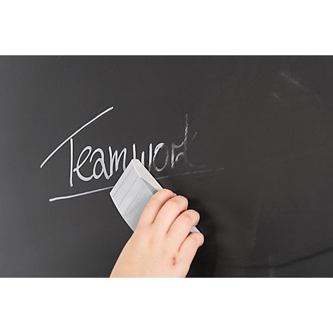 Hand veegt "Teamwork" van schoolbord met gum. Krijtletters bijna verwijderd.