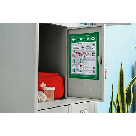 Open cabinet with first aid supplies. Red first aid kit, bandages, cup and emergency poster.