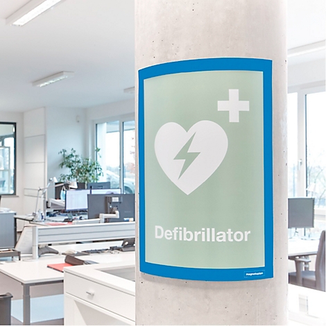 Ein selbstklebender Defibrillator-Hinweisschild auf einer Bürosäule mit Textbeschreibung der Oberflächenhaftung.