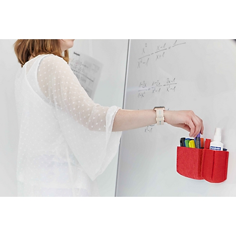 Eine Lehrerin nimmt einen Stift aus einem roten Filz-Organizer, der an einem Whiteboard befestigt ist.