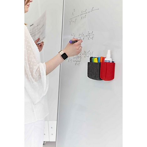 Une personne écrit sur un tableau blanc muni de porte-stylos magnétiques en feutre.