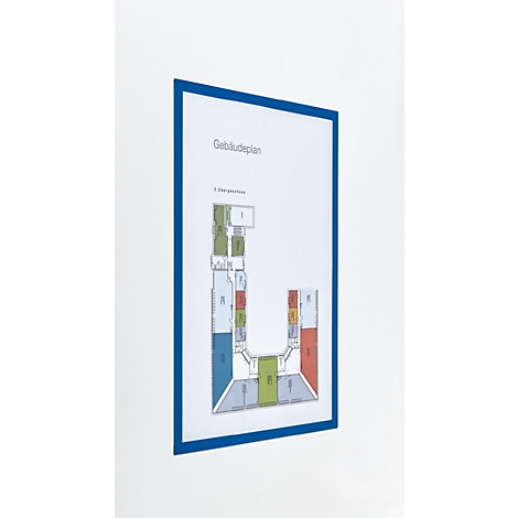 Ein Gebäudeplan in einem blauen Rahmen an einer weißen Wand.