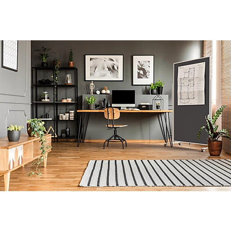 Modernes Heimbüro mit Schreibtisch, Computer, Regal und Pflanzen vor einer dunklen Wand.