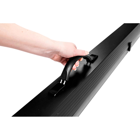 Eine Hand trägt ein schwarzes, längliches Case am schwarzen Griff.