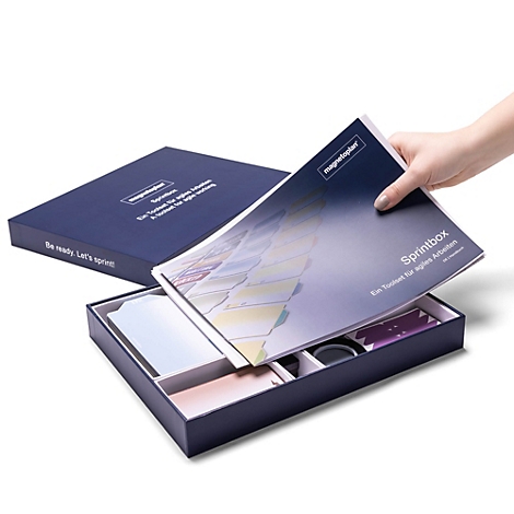 Een hand pakt een brochure uit een open, donkerblauwe Magnetoplan Sprintbox voor agile werken.