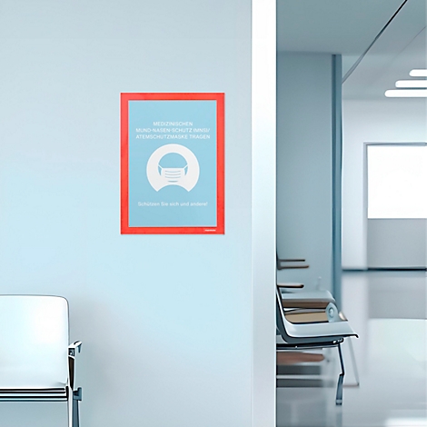 Selbstklebendes Defibrillatorschild an einer Säule und Wand in einem Büro. Text informiert über Haftung auf glatten Flächen.
