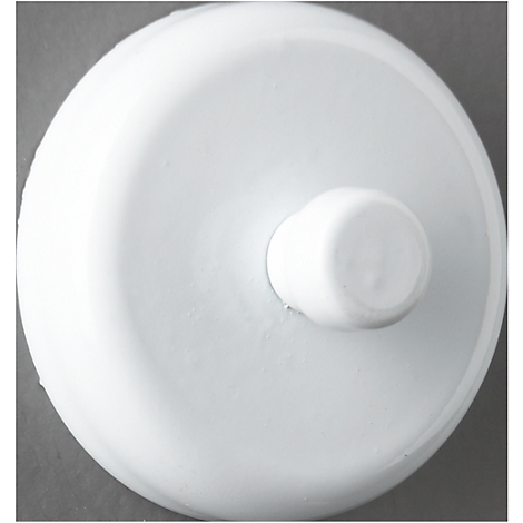 Close-up of a white, circular object with a raised central portion on a gray background.