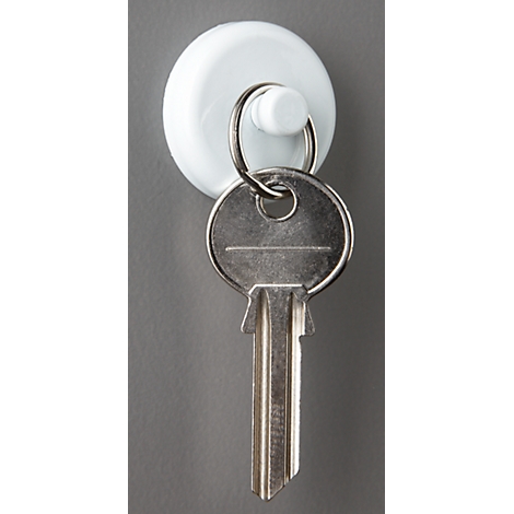 A white key holder with a key. The key is hanging on the holder.