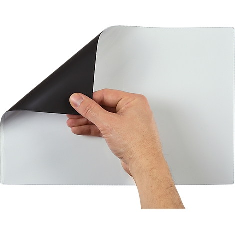 Eine Hand hebt eine Ecke eines weißen Blattes, die Unterseite ist schwarz.