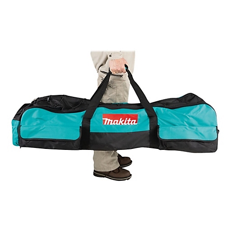 Person trägt eine lange, türkisfarbene Makita-Werkzeugtasche am schwarzen Tragegriff.