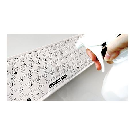 Weiße Tastatur mit Aufschrift MAN & MACHINE, wird mit einer Sprühflasche desinfiziert.