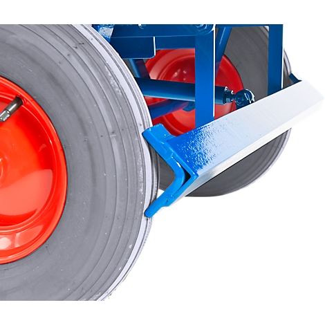 Close-up of a blue and white painted metal part attached to a gray tire. Red rim edge.