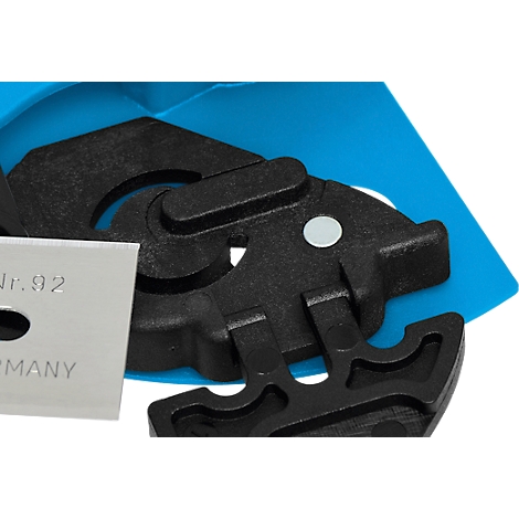 Detailaufnahme einer schwarzen Kunststoff-Komponente mit metallischem Niet und einem Stahlblatt mit "Nr. 92 GERMANY" Beschriftung.