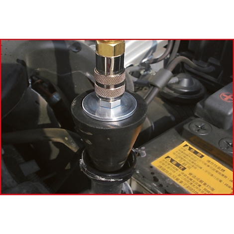 Detailaufnahme eines Werkzeugs, das an einem Fahrzeugmotor befestigt ist. Der Fokus liegt auf der Verbindung.