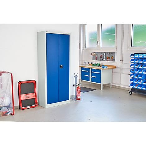 Blau metalen kast in een werkplaats. Gereedschap en blauwe lades op de achtergrond.