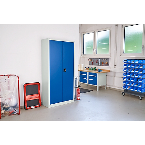 Werkplaats met blauwe kasten en gereedschap. Een brandblusser en een ladder staan ernaast. Lichte omgeving.