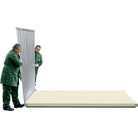 Two men in green overalls are installing a large panel on a white wall.