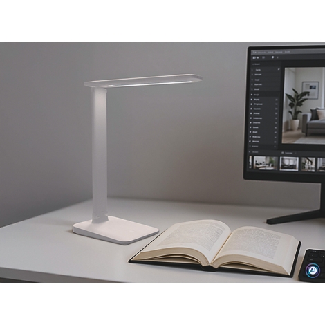 Lampe de bureau blanche éclairant un bureau. Livre ouvert, écran d'ordinateur, appareil domotique.