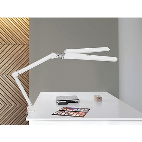Witte bureaulamp boven een tafel. Op de tafel liggen een laptop, kleurstalen en een stuk hout.