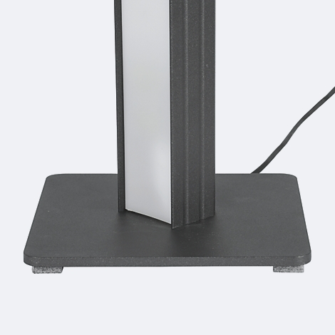 Detailaufnahme einer schwarzen Standleuchte. Der Schaft zeigt einen weißen Leuchtstreifen und steht auf einem schwarzen, quadratischen Fuß. Ein Kabel führt nach hinten.