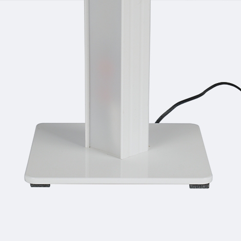 Nahaufnahme eines weißen Objekts mit quadratischer Basis und Säule, Stromkabel im Hintergrund.